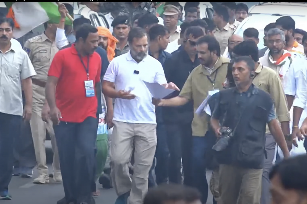 TGPWU president Shaik Salauddin walking alongside Rahul Gandhi and handing him a paper